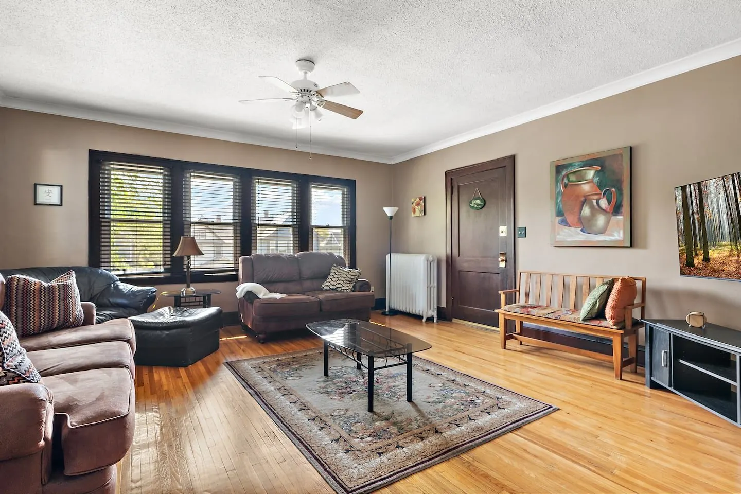 Sun-lit living room with hardwood floors and tall windows